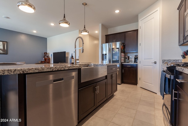 kitchen with light stone countertops, light tile patterned flooring, dark brown cabinets, and stainless steel appliances