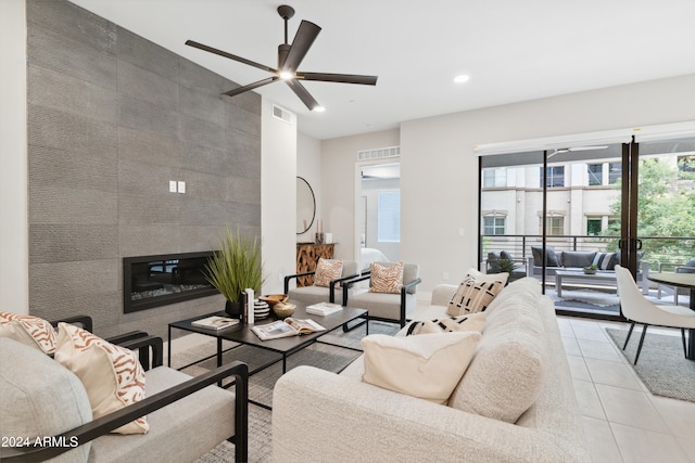 tiled living room with ceiling fan, a fireplace, and tile walls