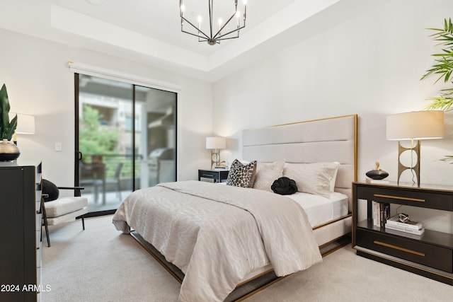 bedroom featuring access to exterior, light colored carpet, and a tray ceiling