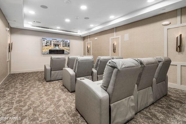 cinema room with carpet floors and a tray ceiling