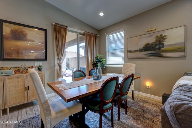 dining area with dark hardwood / wood-style flooring and vaulted ceiling