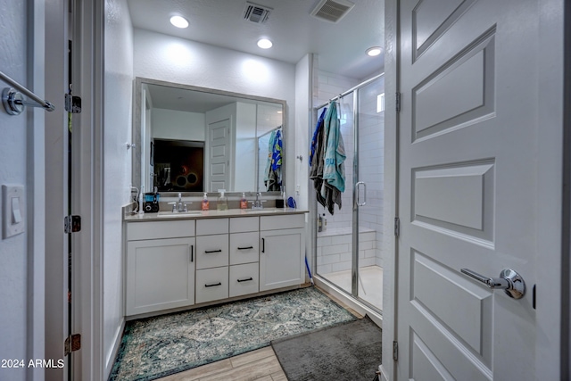 bathroom featuring vanity and a shower with door