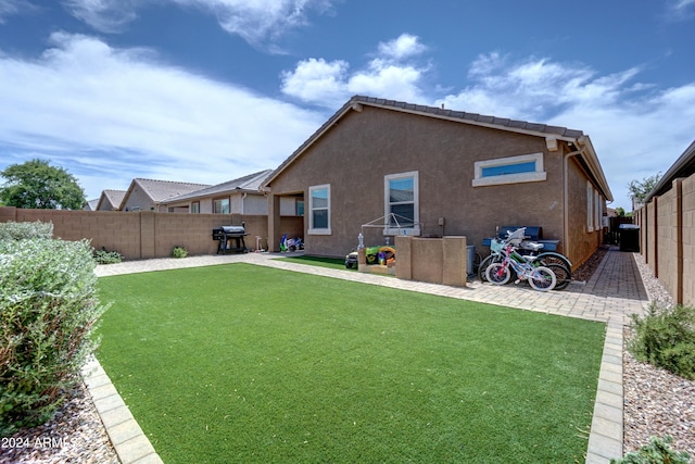 rear view of house with a patio area and a lawn