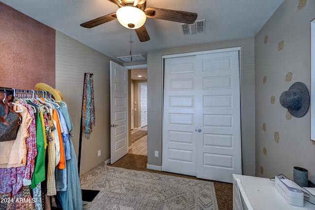 carpeted bedroom with ceiling fan and a closet