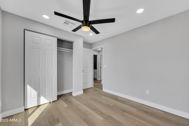 unfurnished bedroom with light hardwood / wood-style flooring, a closet, and ceiling fan