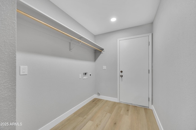 clothes washing area with washer hookup, hookup for an electric dryer, and light wood-type flooring