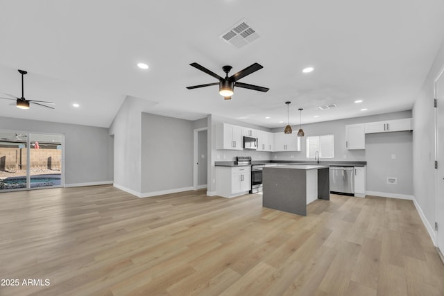 kitchen featuring light hardwood / wood-style flooring, ceiling fan, appliances with stainless steel finishes, white cabinets, and a kitchen island