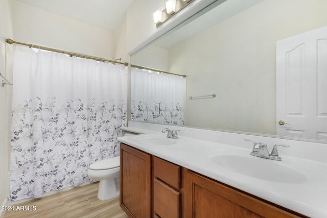 bathroom with vanity, hardwood / wood-style floors, toilet, and walk in shower