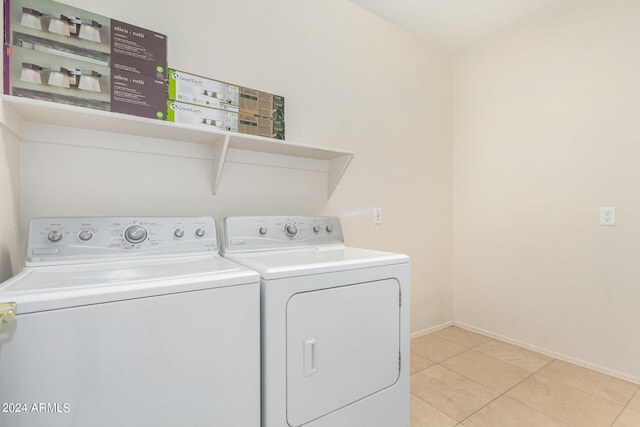 clothes washing area with light tile patterned flooring and washing machine and clothes dryer