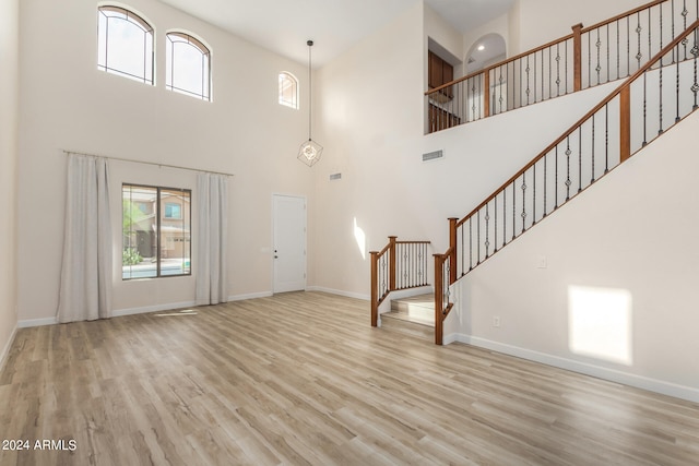 interior space with light hardwood / wood-style flooring and a high ceiling