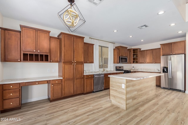 kitchen with stainless steel appliances, sink, light hardwood / wood-style floors, decorative light fixtures, and a center island