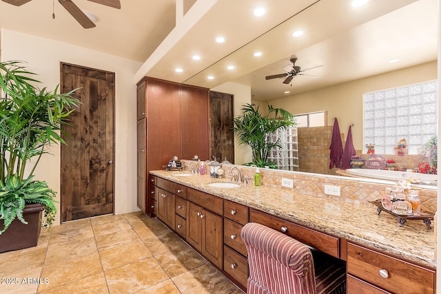 bathroom with ceiling fan, a washtub, and vanity