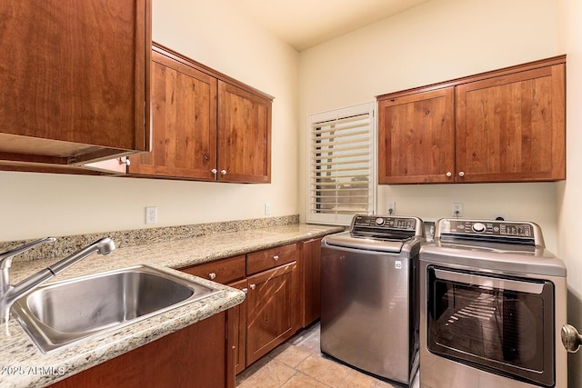 laundry room with cabinets, washing machine and clothes dryer, light tile patterned floors, and sink