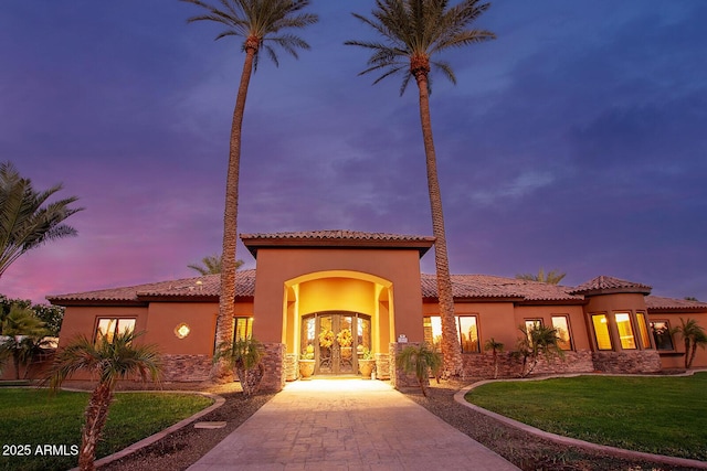 mediterranean / spanish home with french doors and a yard