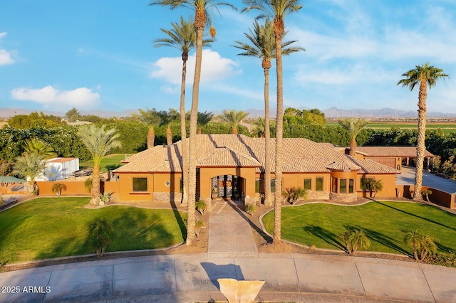 view of front of home with a front lawn and a mountain view