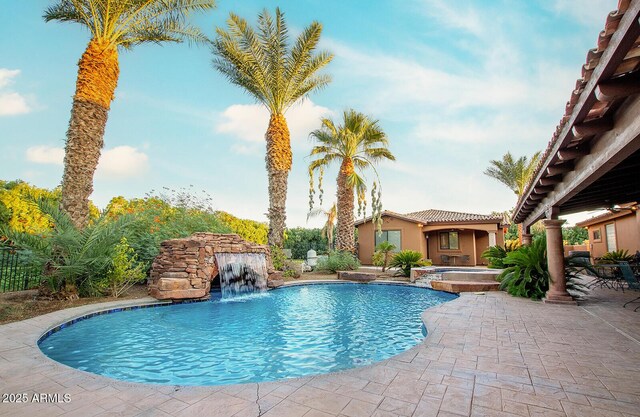 view of pool with pool water feature, an in ground hot tub, and a patio area