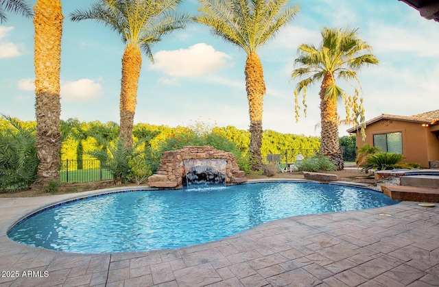 view of pool featuring a patio, pool water feature, and an in ground hot tub