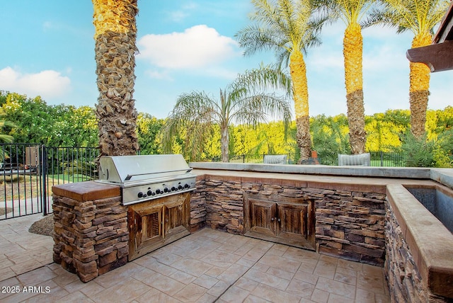 view of patio with an outdoor kitchen and a grill