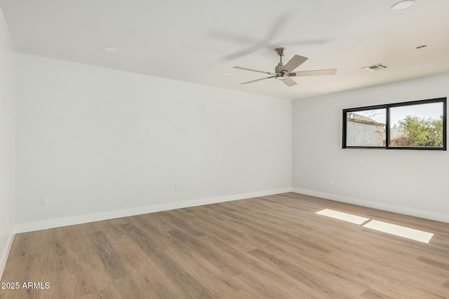 spare room featuring ceiling fan, baseboards, visible vents, and light wood-type flooring