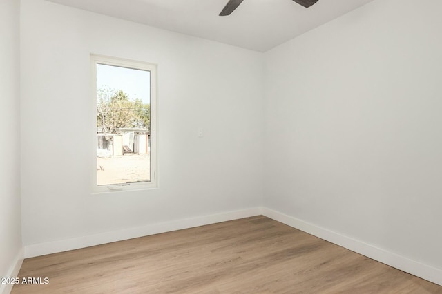 empty room featuring ceiling fan, light wood-type flooring, and baseboards