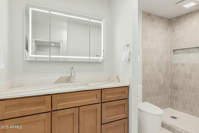 full bath with tiled shower, toilet, and vanity