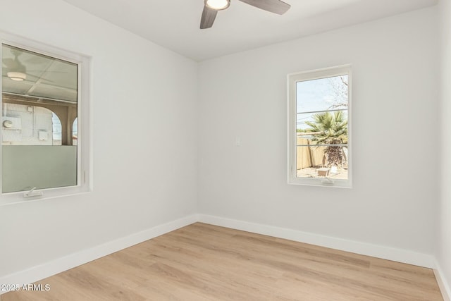 empty room with ceiling fan, baseboards, and wood finished floors