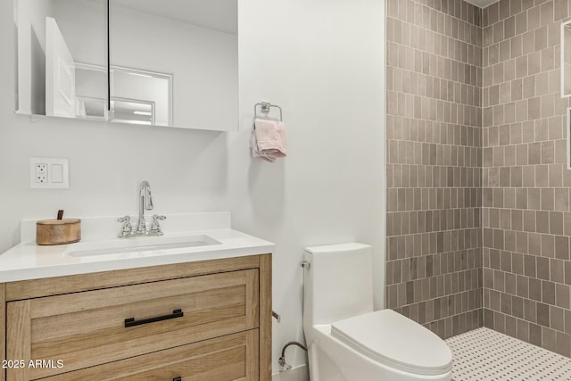 full bathroom with tiled shower, toilet, and vanity