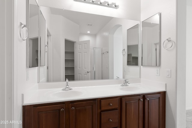 bathroom with double vanity, a sink, and visible vents