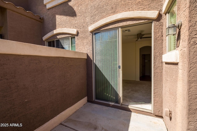 doorway to property featuring visible vents and stucco siding