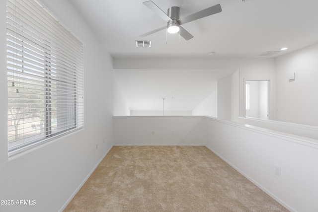 empty room with a ceiling fan, carpet, visible vents, and baseboards