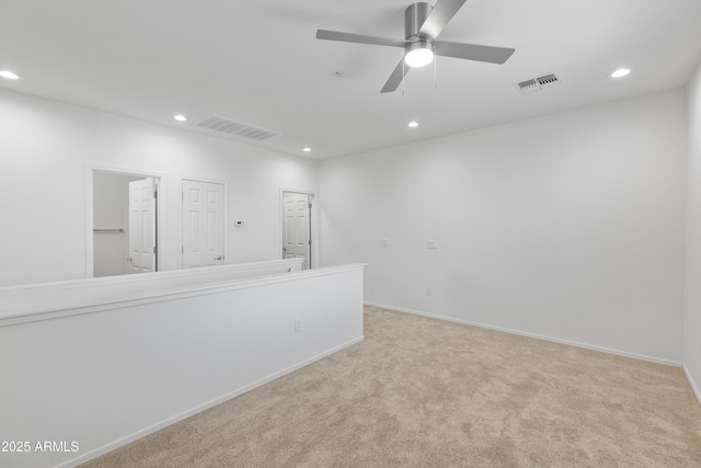 carpeted spare room with ceiling fan, visible vents, and recessed lighting