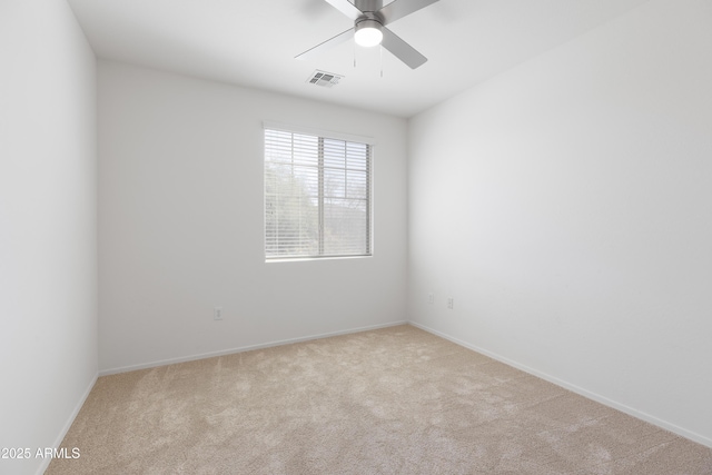 carpeted spare room with ceiling fan, visible vents, and baseboards