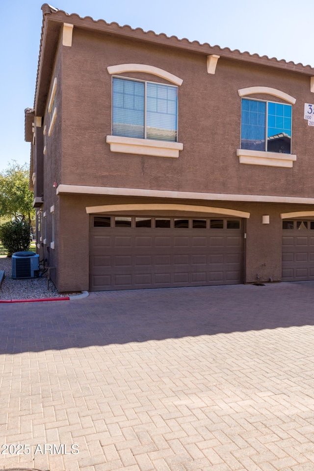 exterior space with cooling unit and stucco siding