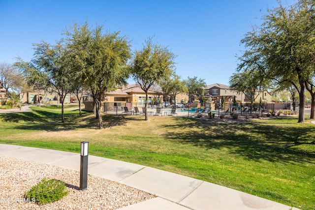 view of community with a residential view, a pool, and a yard