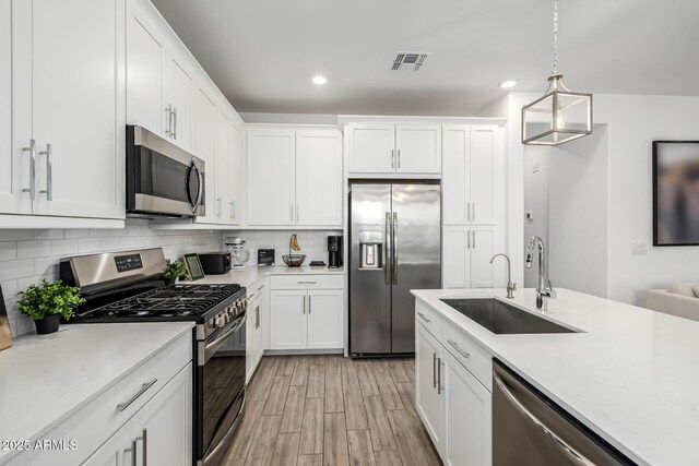 4077 S Sabrina Dr Unit 14, Chandler, AZ 85248 - kitchen featuring decorative backsplash, a sink, white cabinetry, and stainless steel appliances