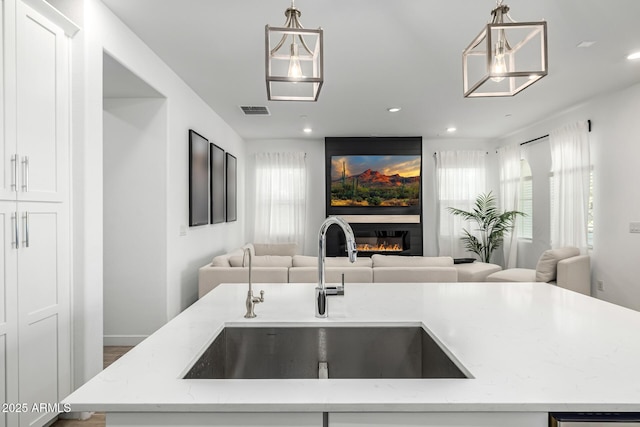 4077 S Sabrina Dr Unit 14, Chandler, AZ 85248 - kitchen featuring a sink, open floor plan, a wealth of natural light, and a glass covered fireplace
