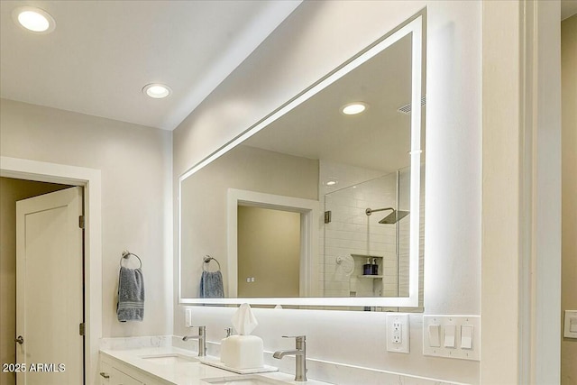 bathroom with double vanity, a stall shower, a sink, and recessed lighting