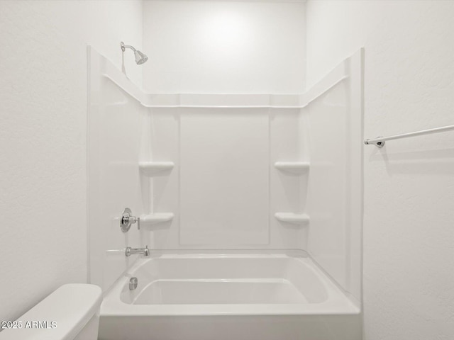 bathroom with toilet and bathing tub / shower combination