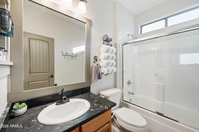 full bathroom featuring vanity, toilet, and combined bath / shower with glass door