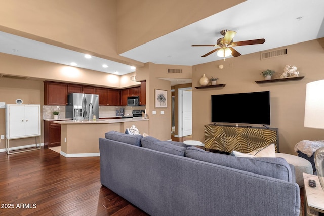 living room with dark wood-type flooring and ceiling fan