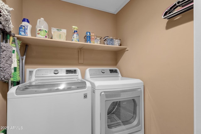 laundry room featuring separate washer and dryer and ornamental molding