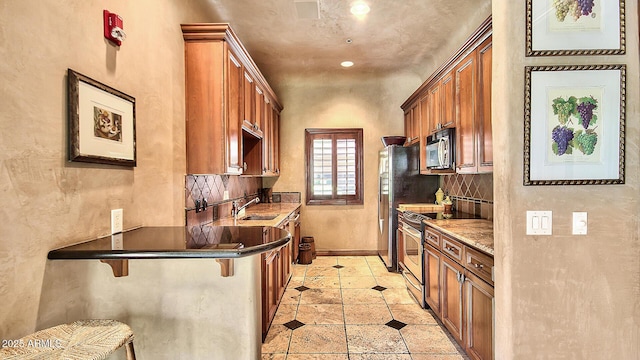 kitchen with tasteful backsplash, sink, a kitchen breakfast bar, stainless steel appliances, and light stone countertops