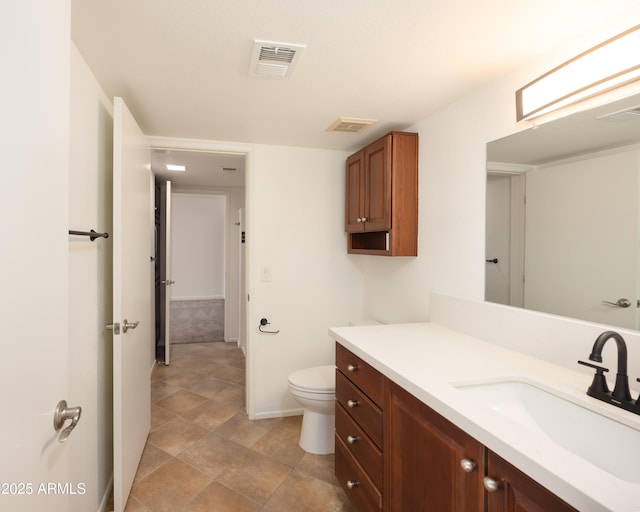 bathroom featuring baseboards, vanity, and toilet