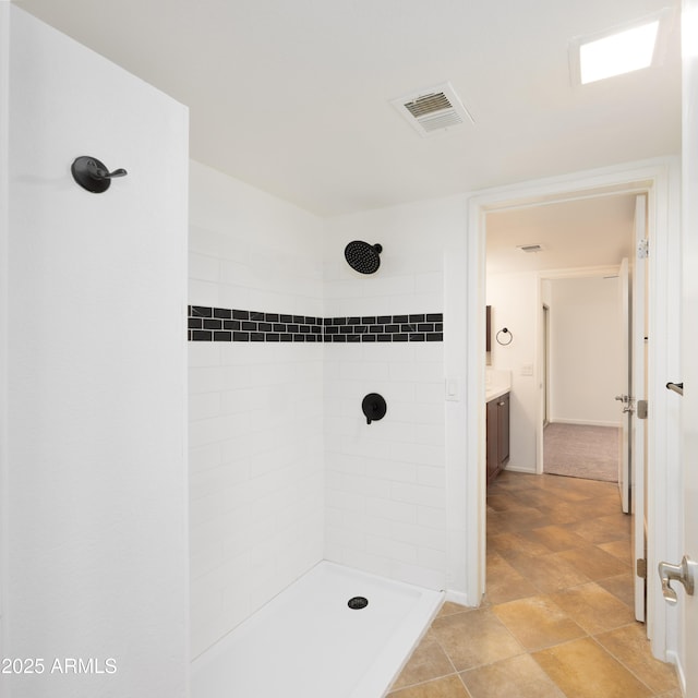 full bathroom with tiled shower and vanity