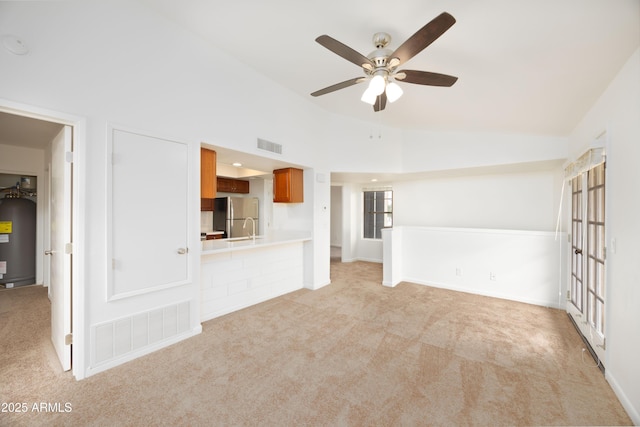 unfurnished living room with carpet, a ceiling fan, lofted ceiling, and a sink