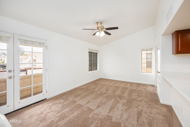 unfurnished living room featuring light carpet, a ceiling fan, lofted ceiling, french doors, and baseboards
