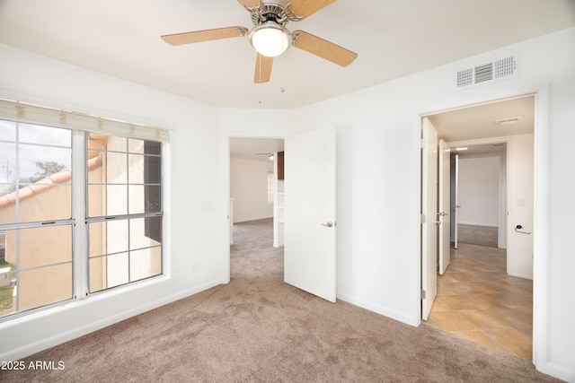 unfurnished room featuring carpet flooring, baseboards, and a ceiling fan