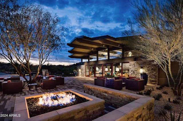 patio terrace at dusk featuring an outdoor living space with a fire pit