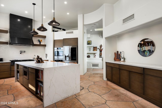 kitchen with hanging light fixtures, tasteful backsplash, a kitchen island, exhaust hood, and stainless steel appliances