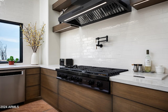 kitchen with light stone counters, tasteful backsplash, dishwasher, black stovetop, and premium range hood